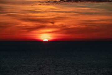 Panoramic sunset view from Sveti Stefan at Adriatic Mediterranean Sea, Budva Riviera, Montenegro, Europe. Reflection of sun beams on water surface during twilight. Summer vacation in seaside resort
