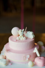 Pink cake with mirror glaze and white chocolate unicorn . Cake on a white cake stand. First birthday party concept