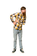 Naklejka premium Young adult redhead man with a long beard standing full body isolated having a liver pain, stomach ache.