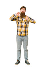 Young adult redhead man with a long beard standing full body isolated showing thumbs up and thumbs down, difficult choose concept