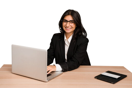 Young indian woman in a table with a laptop and tablet using a mobile phone isolated