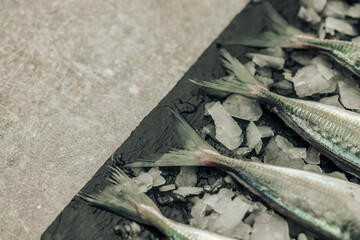 uncooked white fish tails on chopping board with ice