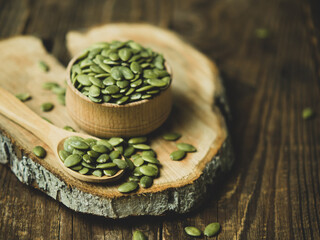 raw pumpkin seeds on old wooden background ,copy space