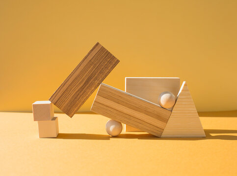Wooden geometric shapes. Geometric composition. Scene with geometrical forms on yellow background.