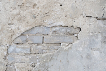 Old brick wall with peeling plaster.