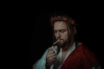 Jesus Christ smokes a cigarette wearing a crown of thorns and white chiton toga cape himation suffering for mankind's sins in artistic portrait