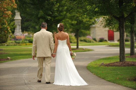 Older Wedding Couple Walking In Park