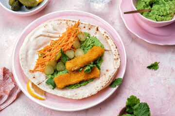 Fish fingers wraps with pea puree and vegetable in tortilla