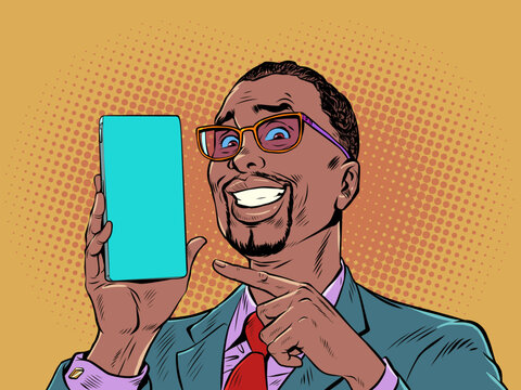 A man with black hair and fashionable glasses smiles and points to the phone. Product demonstration or offer on smartphone. The joy of a perfect purchase. Pop Art Retro
