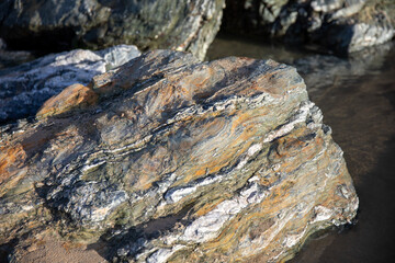 Rocks revealed on the beach at Perranporth during low tide.