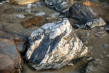 Fototapeta na wymiar Rocks revealed on the beach at Perranporth during low tide.