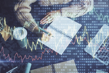 Forex graph on hand taking notes background. Concept of research. Double exposure