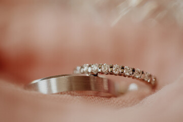 Les alliances des mariés dans un voile rose