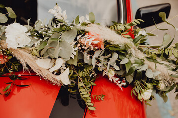 Décoration florale sur le pare-brise de la voiture des mariés