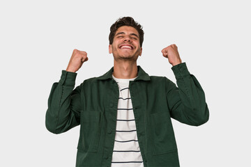 Young handsome caucasian man isolated on white background celebrating a victory, passion and...