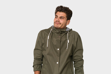 Obraz premium Young handsome caucasian man isolated on white background shrugs shoulders and open eyes confused.