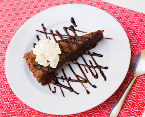 Image of sweet brownie cake with chocolate and butter cream served at plate