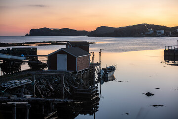 Red fishing shack reflects on the water in Twillingate Newfoundland 