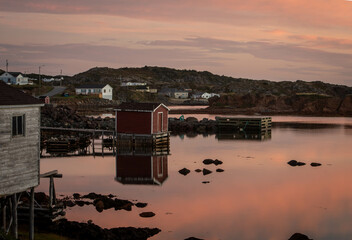 Fototapeta na wymiar Red fishing shack reflects on the water in Twillingate Newfoundland 