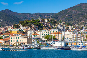 Fototapeta na wymiar Sanremo, Italy, day view from the sea with boats and yachts to the old town of Sanremo (La Pigna) and Madonna della Costa Church on the hilltop, Liguria, Italy