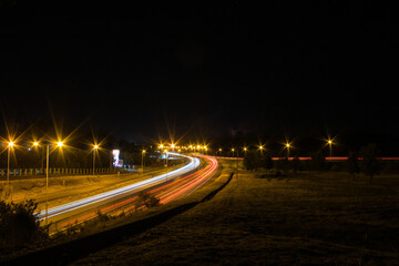 Carretera iluminada con las luces que destellan de los vehículos que circulan
