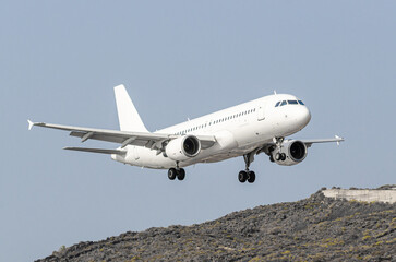 Fototapeta na wymiar Avión de color blanco Airbus A320 Aterrizando en el aeropuerto de La Palma en España