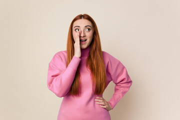 Young red hair woman isolated shouting excited to front.