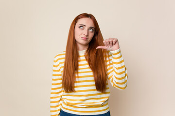 Young red hair woman isolated showing a dislike gesture, thumbs down. Disagreement concept.