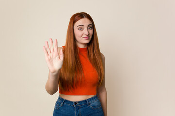 Young red hair woman isolated rejecting someone showing a gesture of disgust.