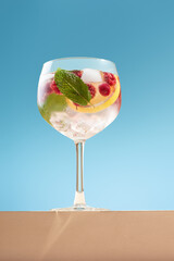 Mojito with lemon and mint on blue background