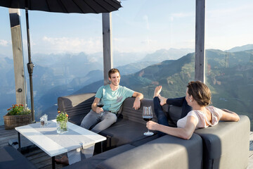 Young couple drinking wines on terrace, Zillertal, Tyrol, Austria