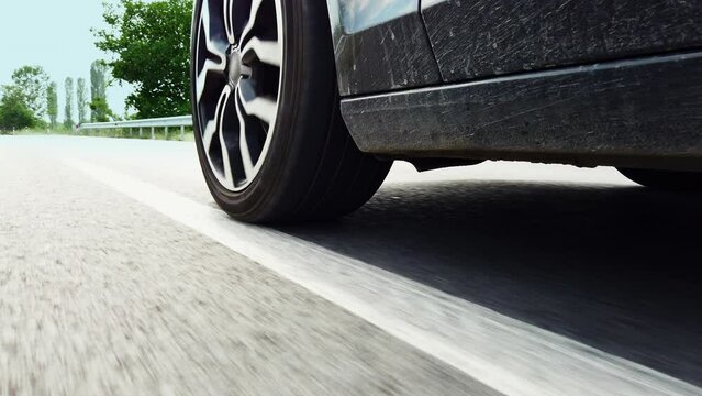Car wheels, tires close up on a background of asphalt speeding on the highway