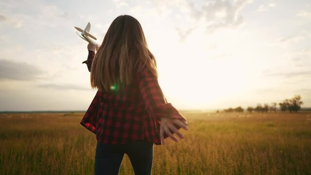 little girl runs with an airplane silhouette in the park. happy family kids concept. the child dreams of becoming an astronaut pilot, the concept of a happy. child runs with an dream plane childhood