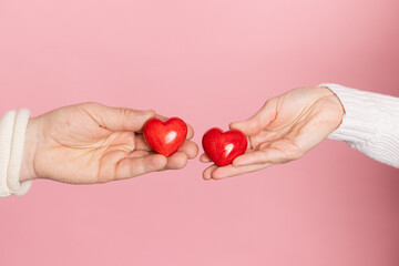 closeup hands holding heart on pink background, valentine's day concept