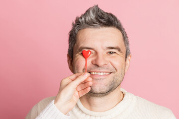 guy and girl holding heart together on pink background, valentine's day concept