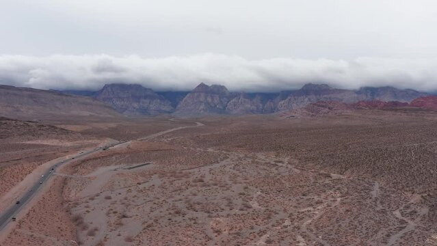 Aerial wide rising and panning shot of Red Rock Canyon on a moody cloudy day in Las Vegas, Nevada. 4K