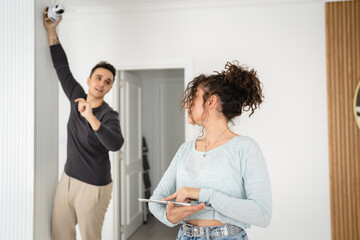 Fototapeta premium man and woman couple wife husband set up surveillance security camera