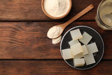 Agar-agar jelly and powder on wooden table, flat lay. Space for text
