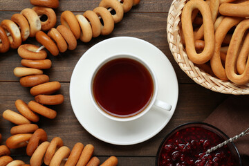 Flat lay composition with delicious ring shaped Sushki (dry bagels) and cup of tea on wooden table