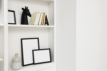 Books, frames and different decorative elements on shelving unit indoors, space for text