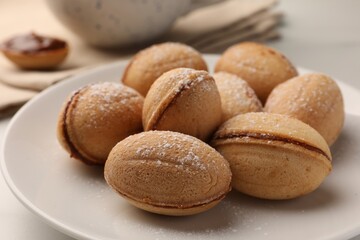 Homemade walnut shaped cookies with condensed milk on white table, closeup