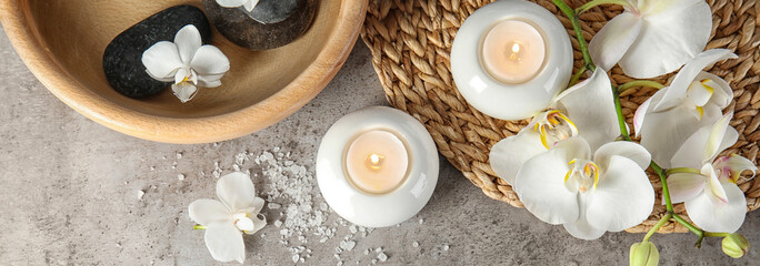 Spa treatment. Flat lay composition with stones and candles on gray table. Banner design