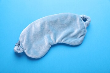 Soft sleep mask on light blue background, top view
