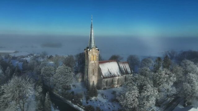 A rare weather phenomenon white rainbow behind the Church of Blessed Virgin Mary in J&otilde;el&auml;htme. Estonia.