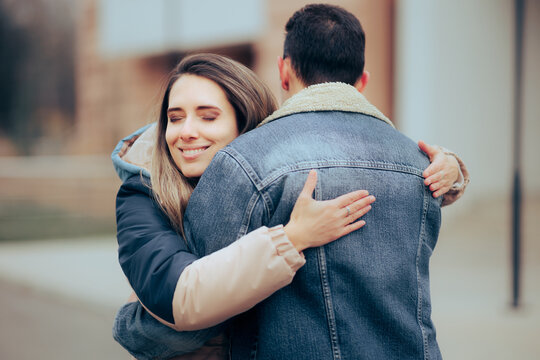 Happy Woman Meeting Her Date and Hugging. Cheerful girlfriend and boyfriend hugging each other with love
