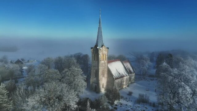 A rare weather phenomenon white rainbow behind the Church of Blessed Virgin Mary in J&otilde;el&auml;htme, Estonia.