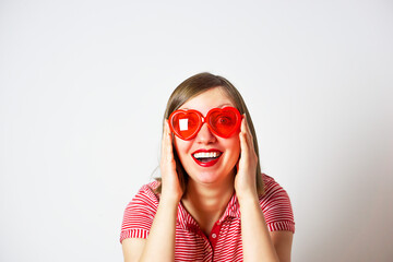 Valentines Day portrait of pretty smiling woman in red sunglasses on the white background.