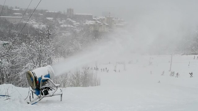 snow gun (pulverizer) disperse artificial snow on high mountain, winter seasonal environment, white hill diversity