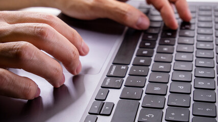 Hands of young boy typing on laptop