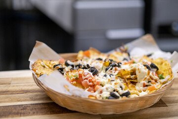 Plate of nachos being prepared in a restaurant kitchen